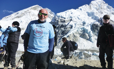 Phil Frier in his office at K College. Inset: Frier completes his 2013 trek to Everest Base Camp