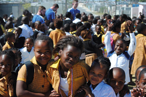 The Hugh Baird team get swamped by primary school children upon arriving in Cape Town 