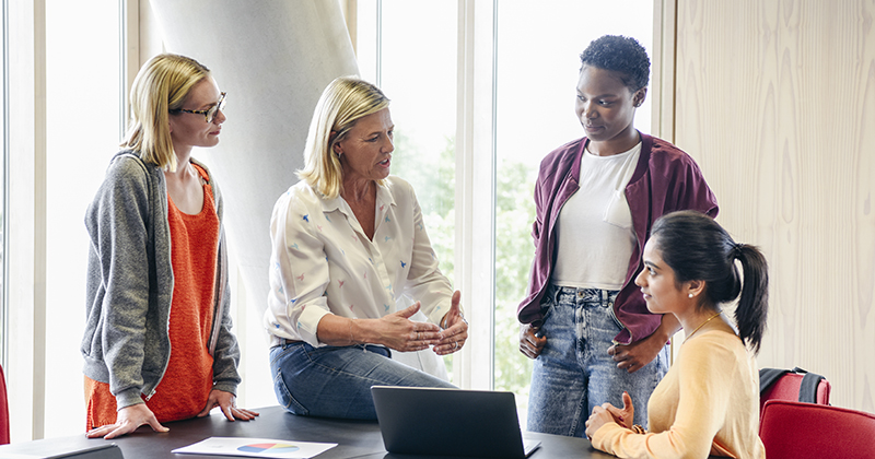 Mature female teacher explaining to three female college students | FE Week