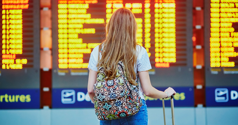 Tourist girl with backpack in international airport | FE Week international students