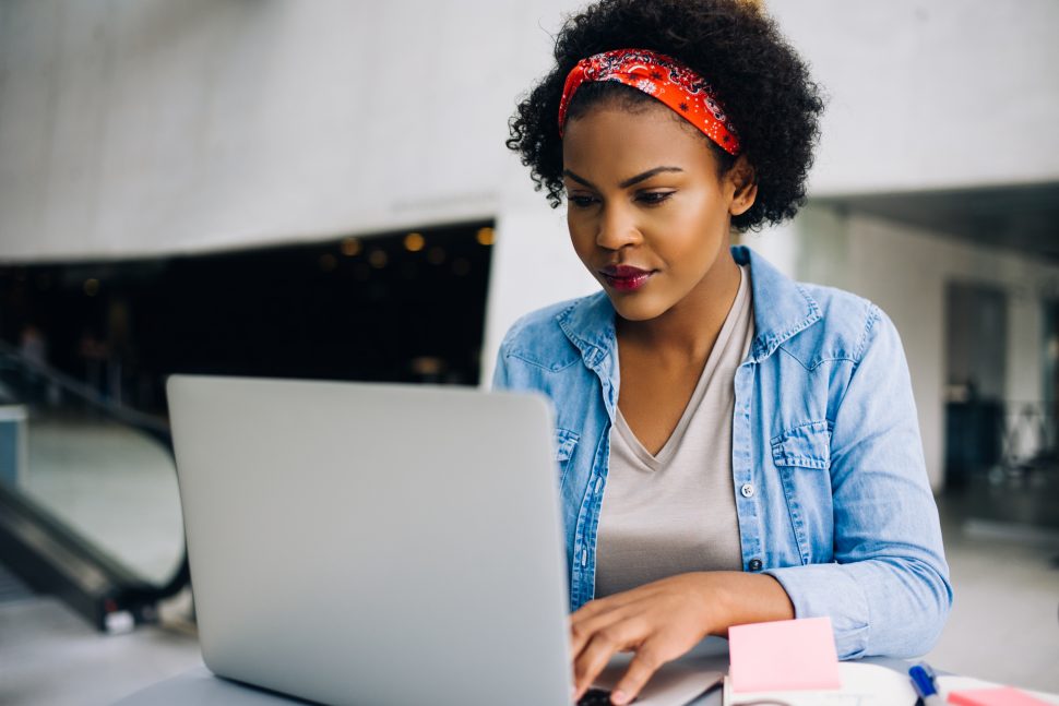 Confident young African female entrepreneur working on a laptop | FE Week