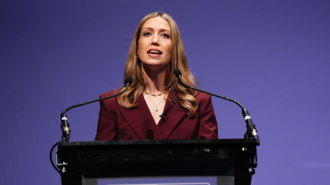 Laura Trott speaks from the conference lecturn